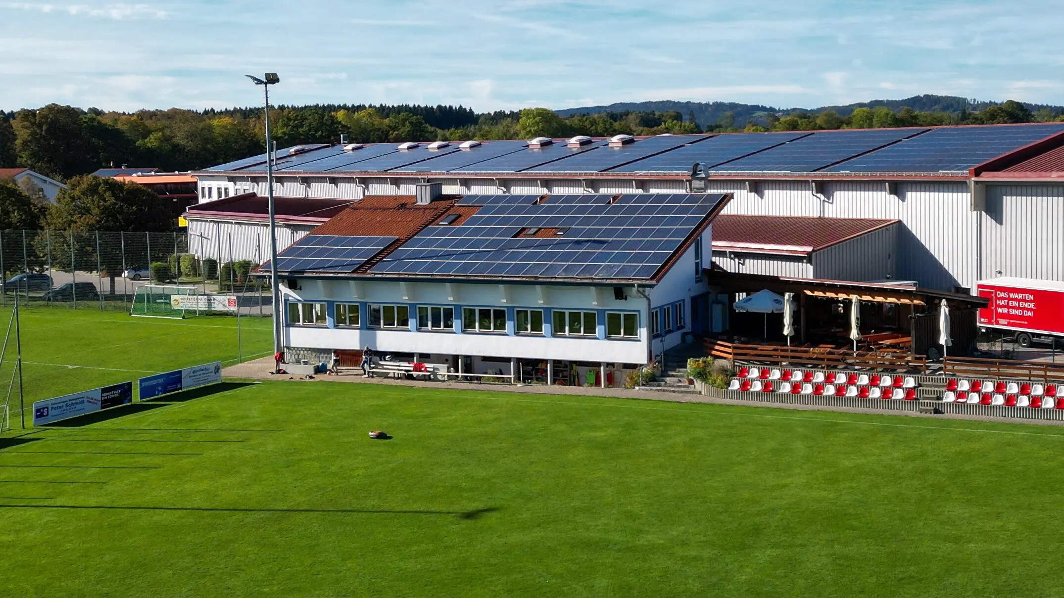 Vereinsheim mit Tribüne und Terrasse, frontal über den Hauptplatz